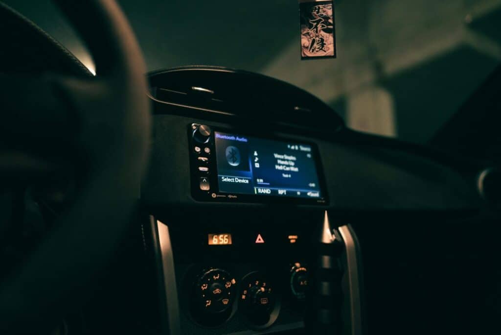 Car dashboard showing an audio system display in a dimly lit interior, focusing on technology.