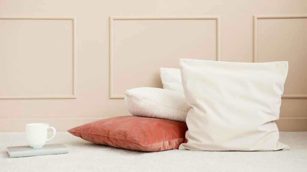 Simple setup with pastel tones and cozy pillows on a soft carpet.