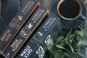 A stack of books sitting next to a cup of coffee