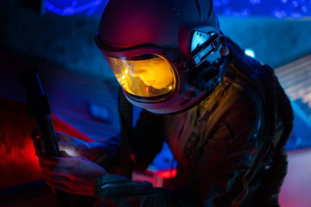A female astronaut explores a futuristic environment with bright blue and red lighting.
